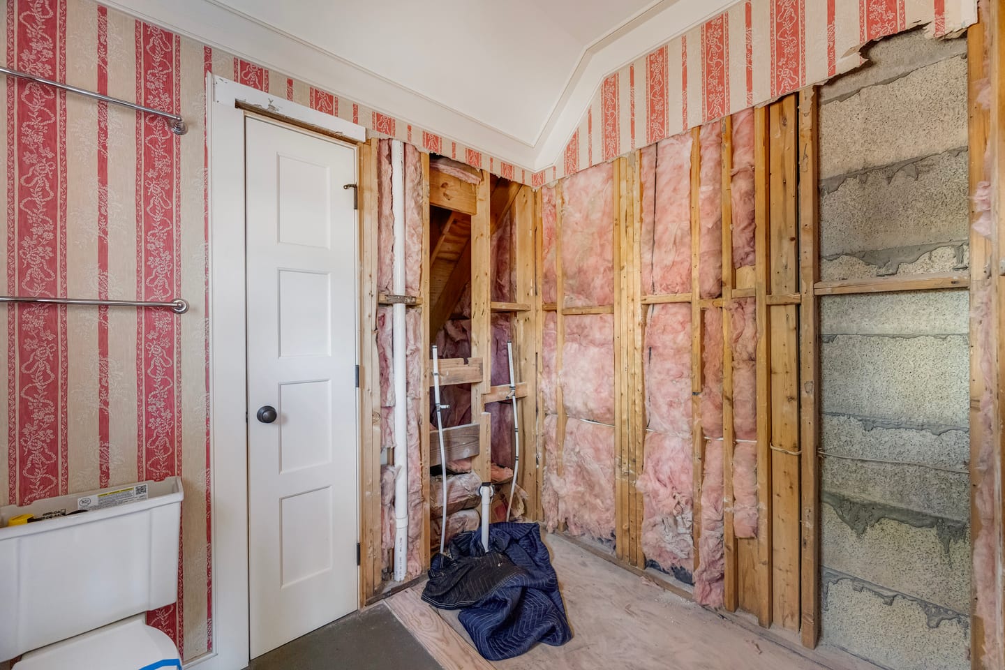 Demolition under way: wallpaper stripped back to gutted stud walls