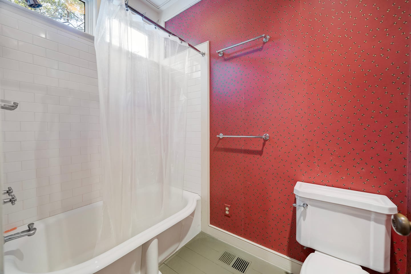 The original hall bath before renovation: soaking tub and patterned red wallpaper