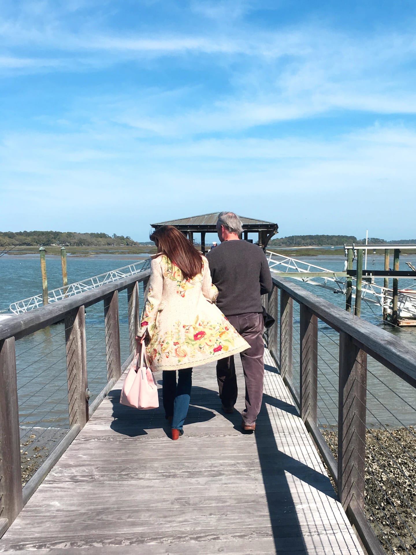 Lisa Furey and Jim Colton walking along a dock over the marsh