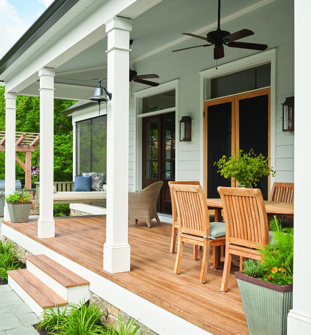 The Huckleberry covered back porch: white columns, ceiling fans and teak dining chairs